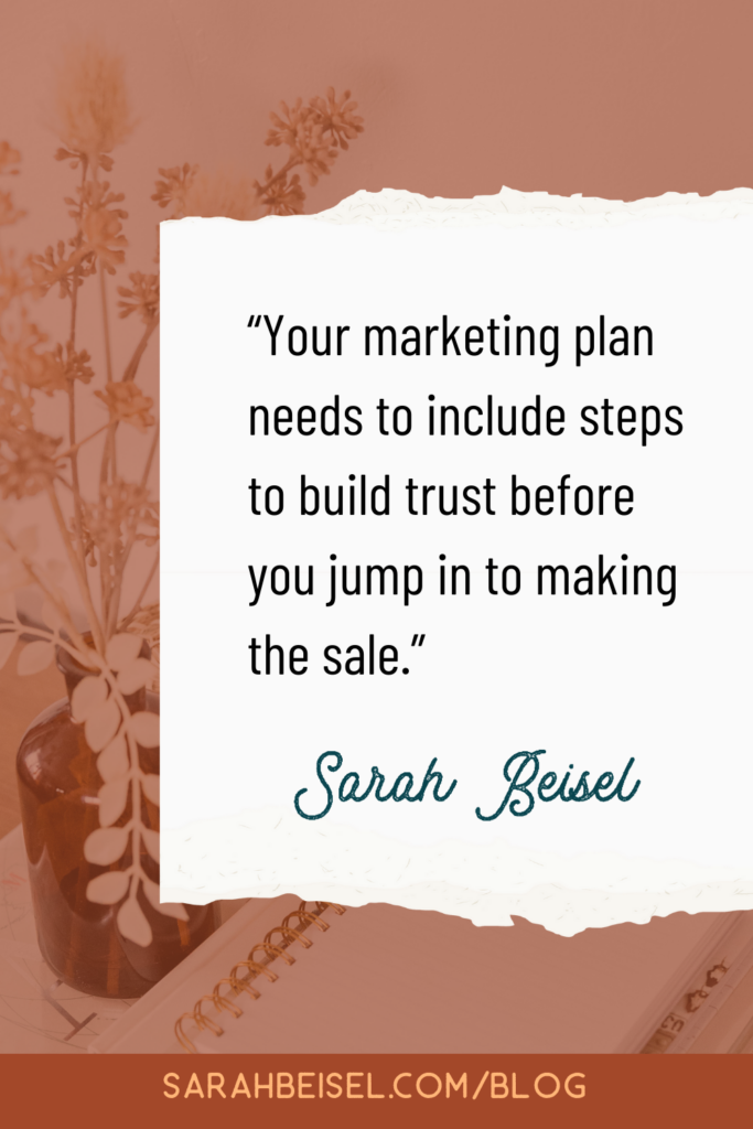 dark orange background with a white piece of paper in the center and text inside reading your marketing plan needs to include steps to build trust before you jump in to making the sale.